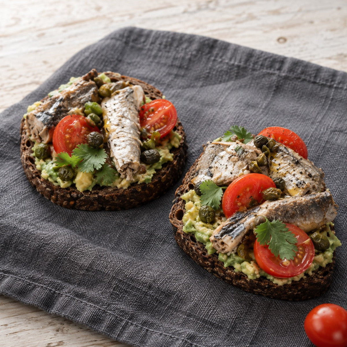 Rye bread toast with avocado, sardines, cherry tomatoes and coriander